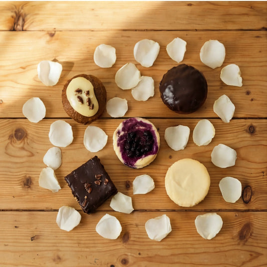 Top-down 5-piece dessert tasting box with carrot cake, cheesecakes, brownie and tart by Flower Guy