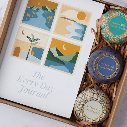 Close-up of the Everyday Calm Gift Box featuring a journal with serene illustrations and a set of three scented soy wax candles.