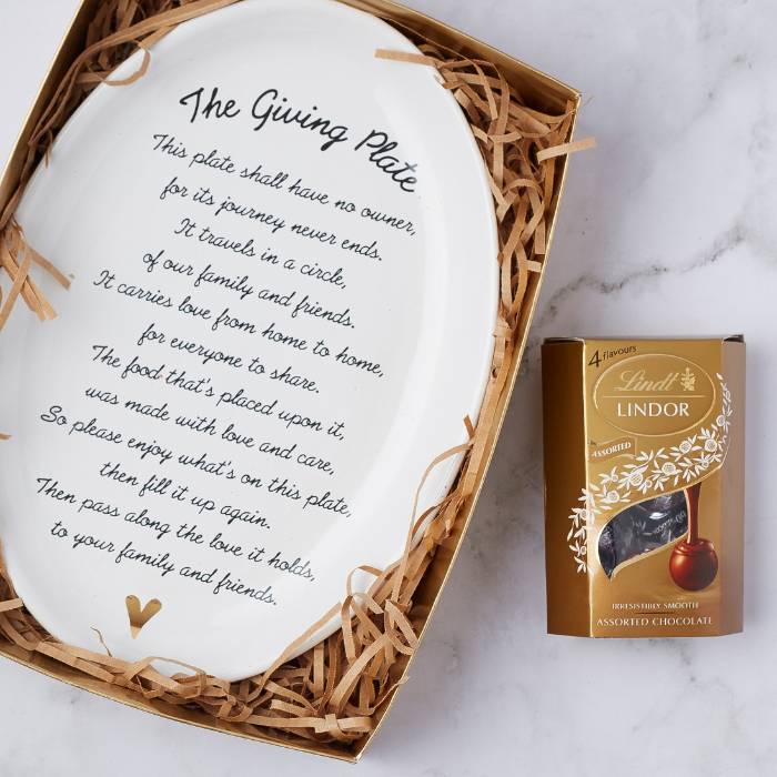 Close-up of The Pass the Love Gift Set with decorative ceramic plate and box of Lindt chocolates in a gift package.
