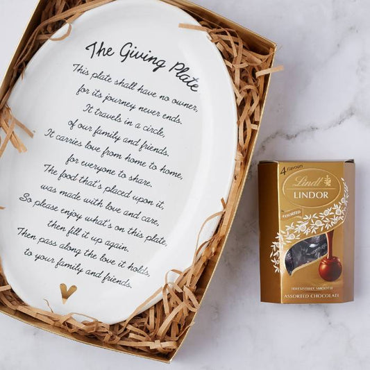 Close-up of The Pass the Love Gift Set with decorative ceramic plate and box of Lindt chocolates in a gift package.