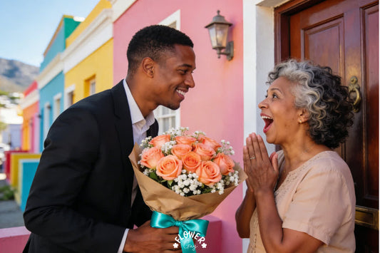 Coloured South African son in a suit surprising his delighted mother with a bouquet of peach roses wrapped in kraft paper with a teal ribbon outside a colourful Bo-Kaap house in Cape Town