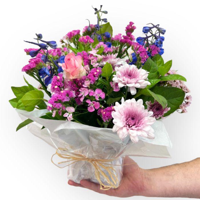 Flower posy with light pink flowers, roses, chrysanthemums, statice and blue delphinium - Flower Guy