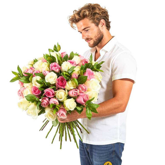 Blush Rush bouquet—man holding 60 blush pink and cream roses with greenery, delivered by Flower Guy