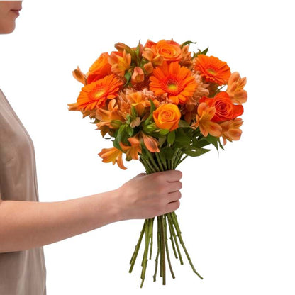 Bouquet of orange flowers held by a person against a white background