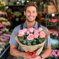 Lush Pink Roses in Charming Blooms Bouquet with Greenery held by male florist | Flower Guy