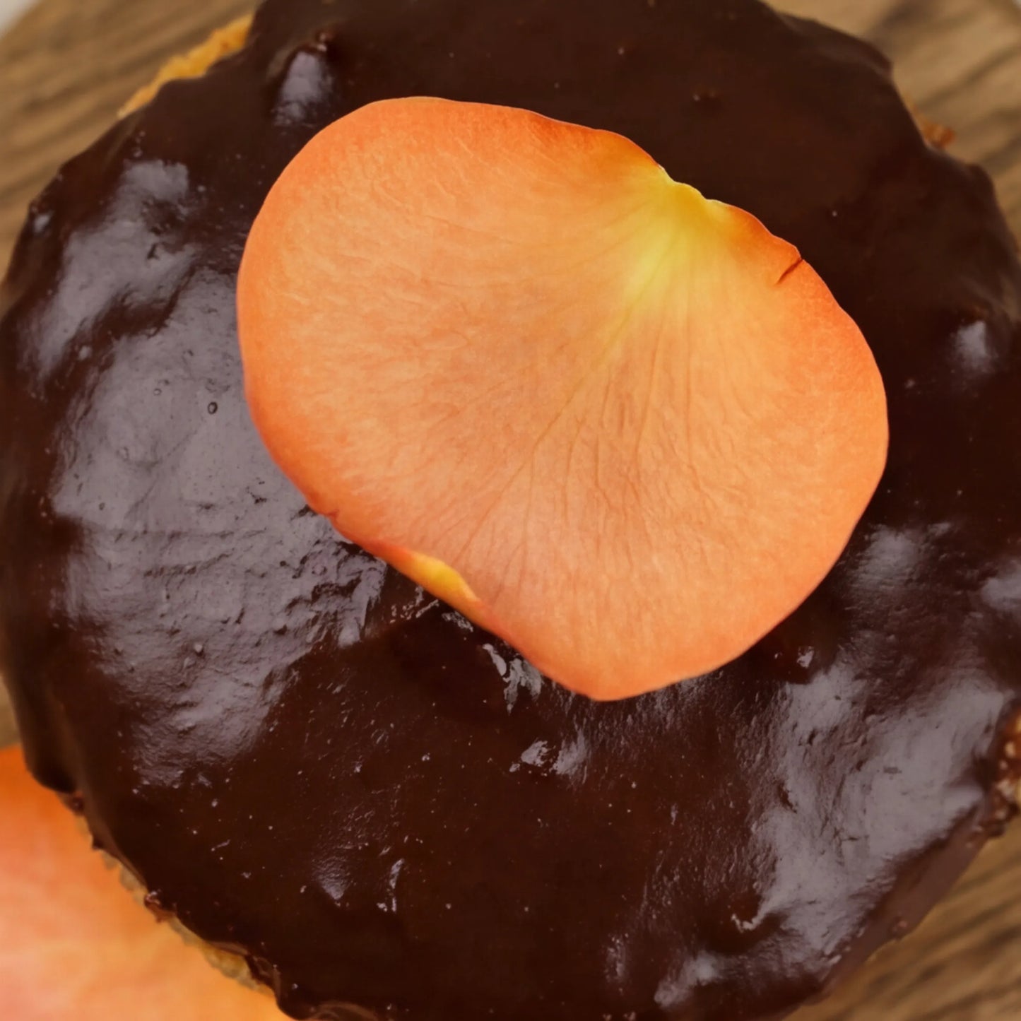 Close-up of dark chocolate ganache with orange rose petal on GF chocolate orange cake by Flower Guy