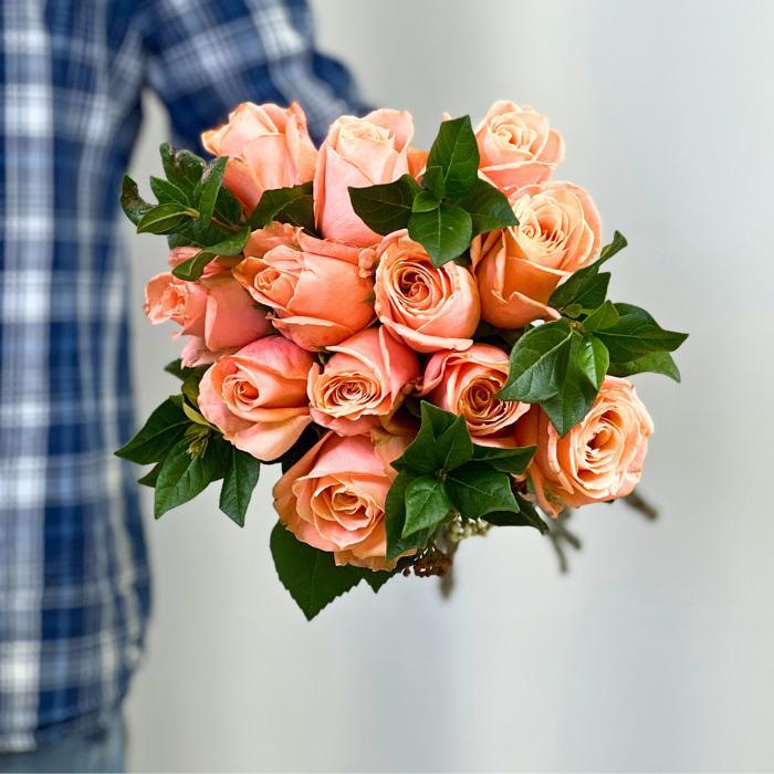Close-up of Coral Charm Rose Bouquet wrapped elegantly - Flower Guy