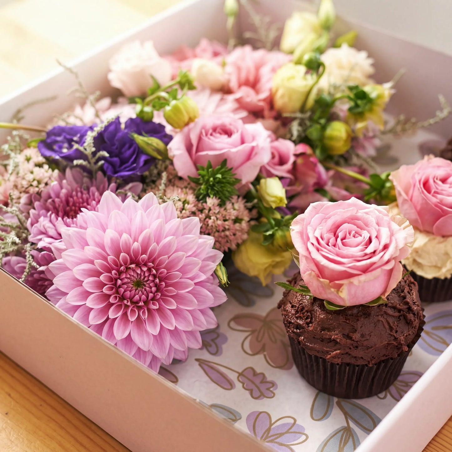 Detail of pink dahlia, roses and chocolate cupcake with fresh rose topper by Flower Guy Cape Town