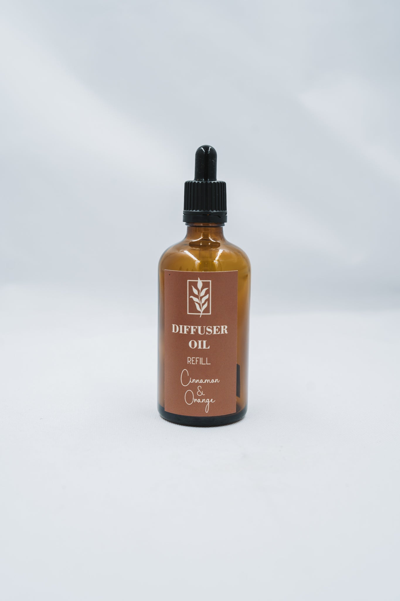 Bottle of diffuser oil with a brown label on a white background