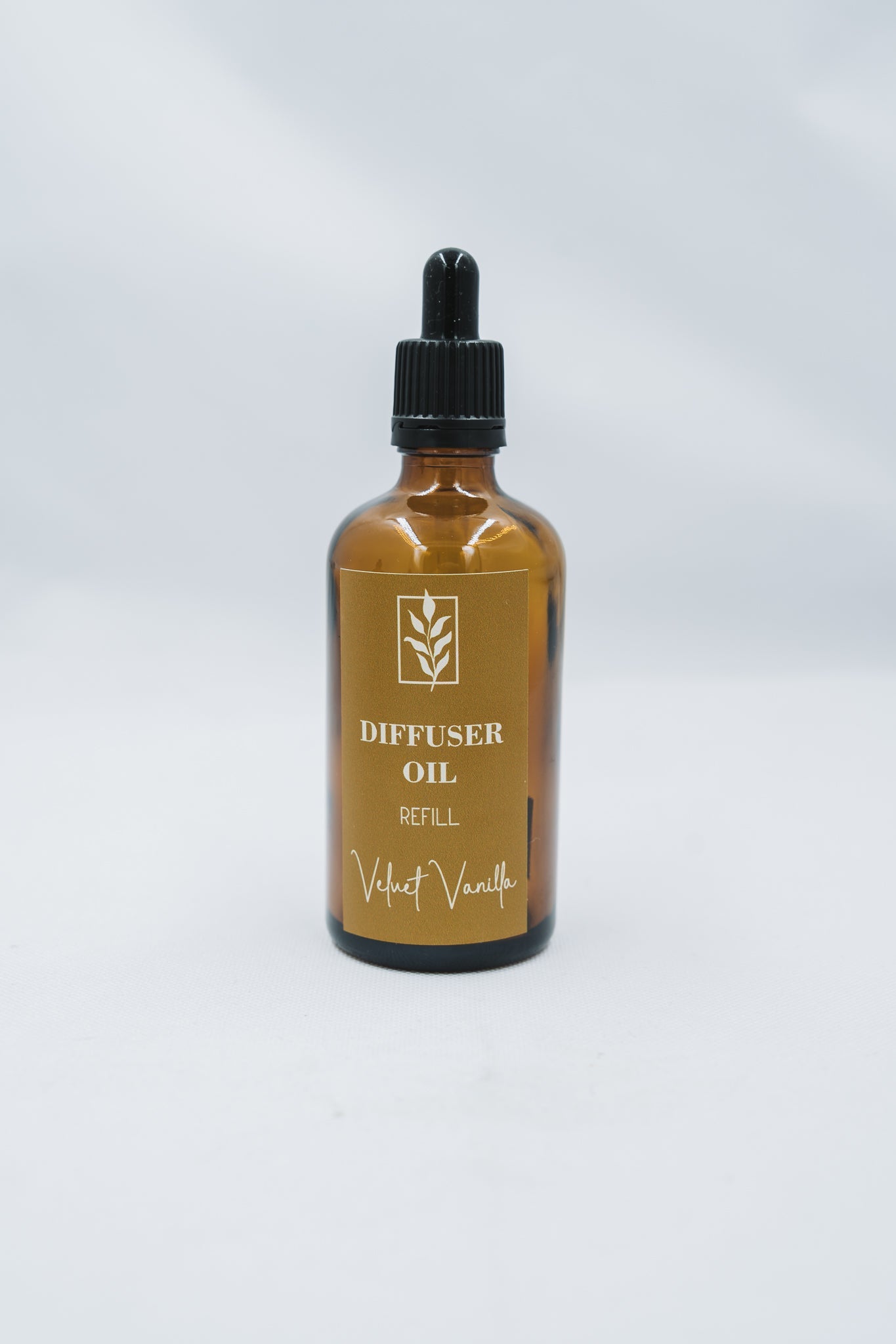 Bottle of diffuser oil labeled 'Velvet Vanilla' on a white background