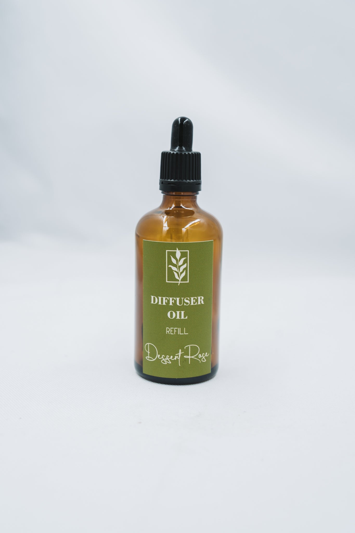 Bottle of diffuser oil with a green label on a white background