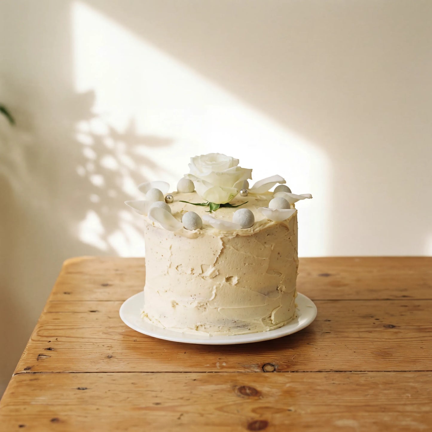 Elegant Rose Celebration Cake with white rose and silver pearls on white plate by Flower Guy Cape Town