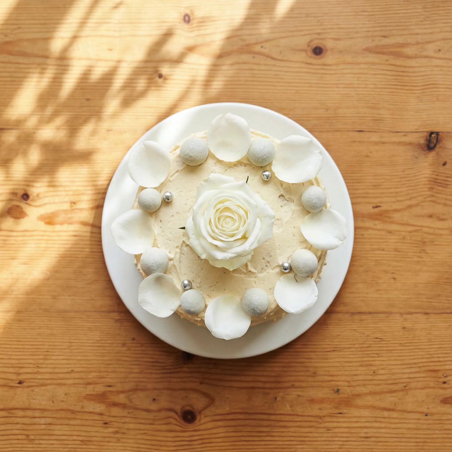 Top-down Elegant Rose Celebration Cake with petal crown and pearl border, hand-decorated in Cape Town