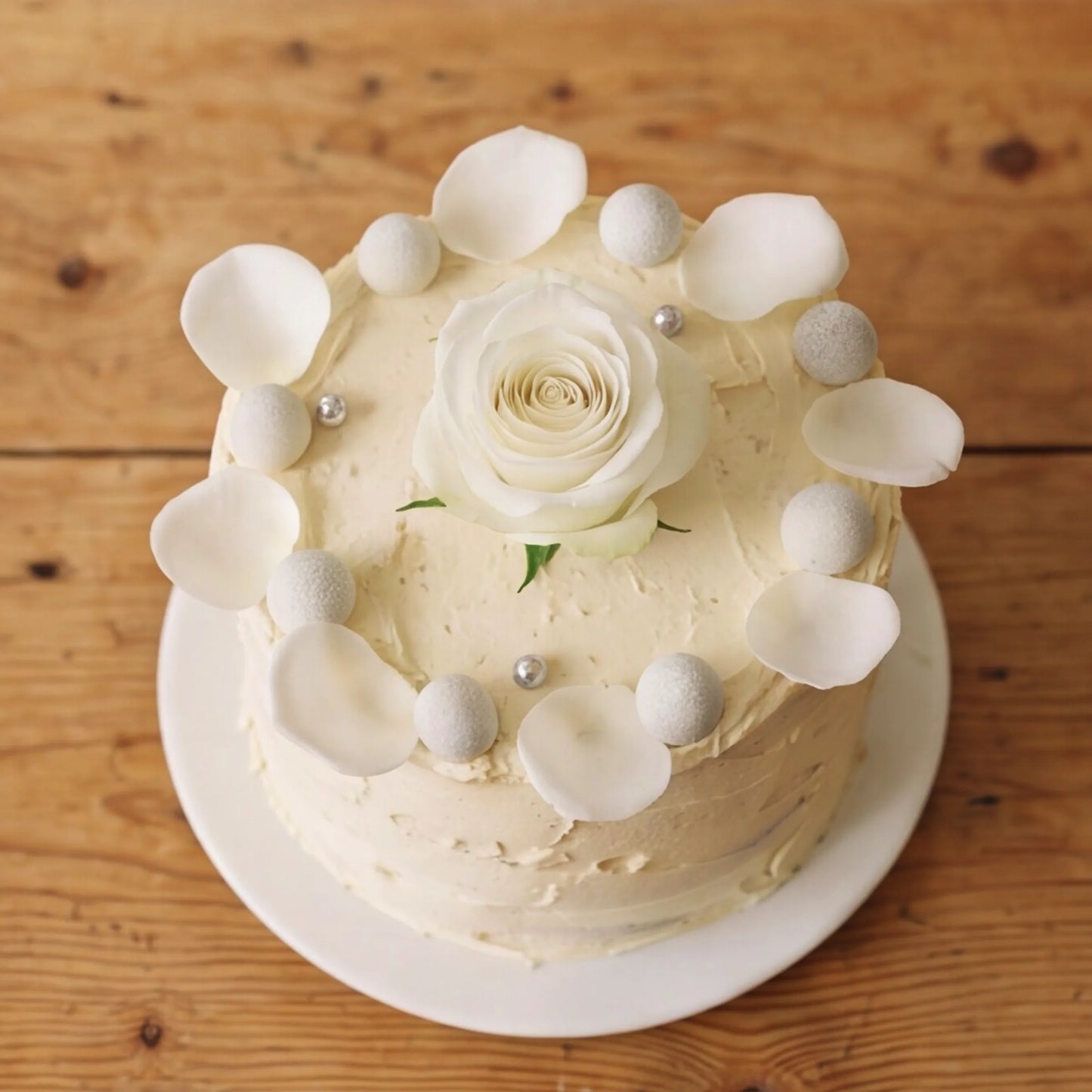 Close-up of white rose centre and silver pearl crown on Elegant Rose Celebration Cake by Flower Guy