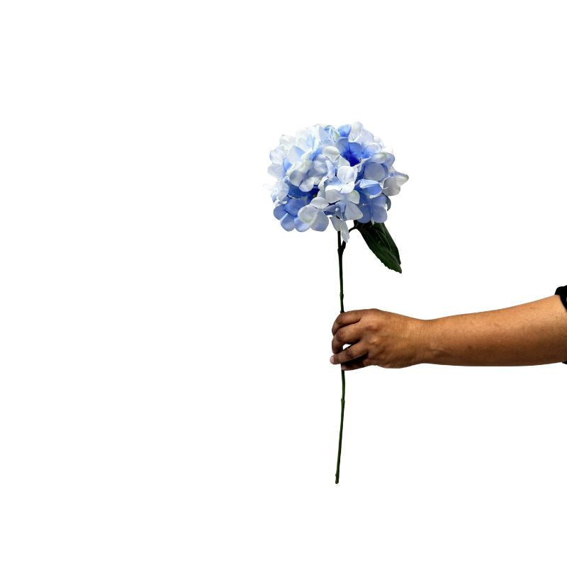 Hand holding a blue artificial flower against a white background