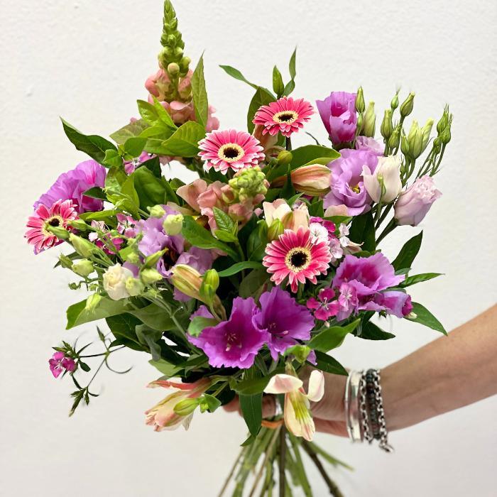 Bright pink and lilac flower bouquet with gerberas in full bloom with lilac lisianthis and greenery - Flower Guy