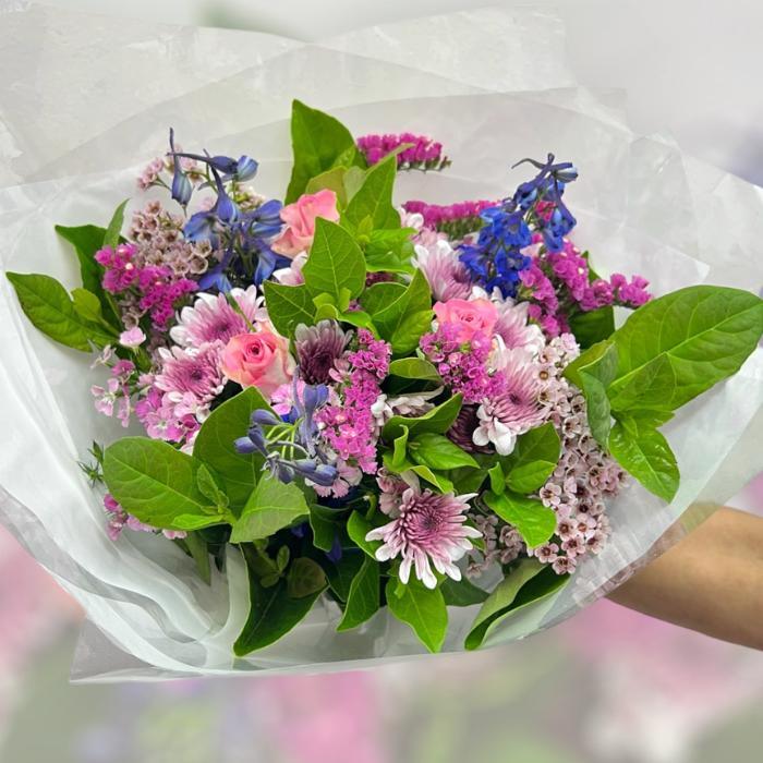 Bouquet of pink flowers with chrysanthemums, roses, wax, greenery and blue delphinium - Flower Guy