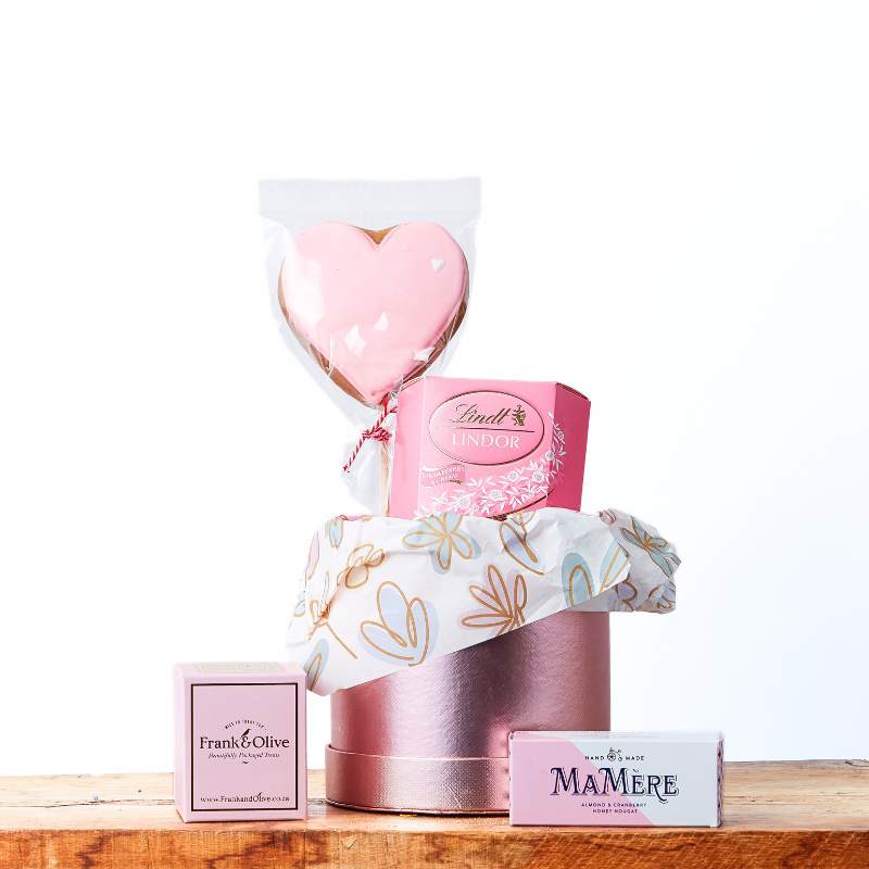 Love and Delight gift box with heart balloon, pink treats, Lindt truffles and nougat stacked on gift boxes | Flower Guy