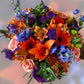 Vibrant floral ensemble as a gift for her to boost her mood with peach roses, orange gerberas and blue delphinium - Flower Guy