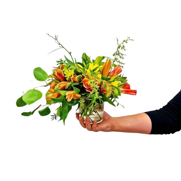 Mr Brightside arrangement close-up—bright orange blooms with fresh greens, gift-ready and held in hand | Flower Guy