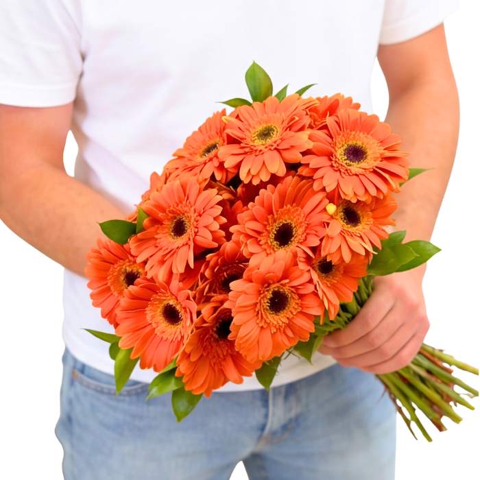 Orangina Blossom Gerbera Bouquet—person holding 20 orange gerberas with greenery, hand-tied bouquet | Flower Guy