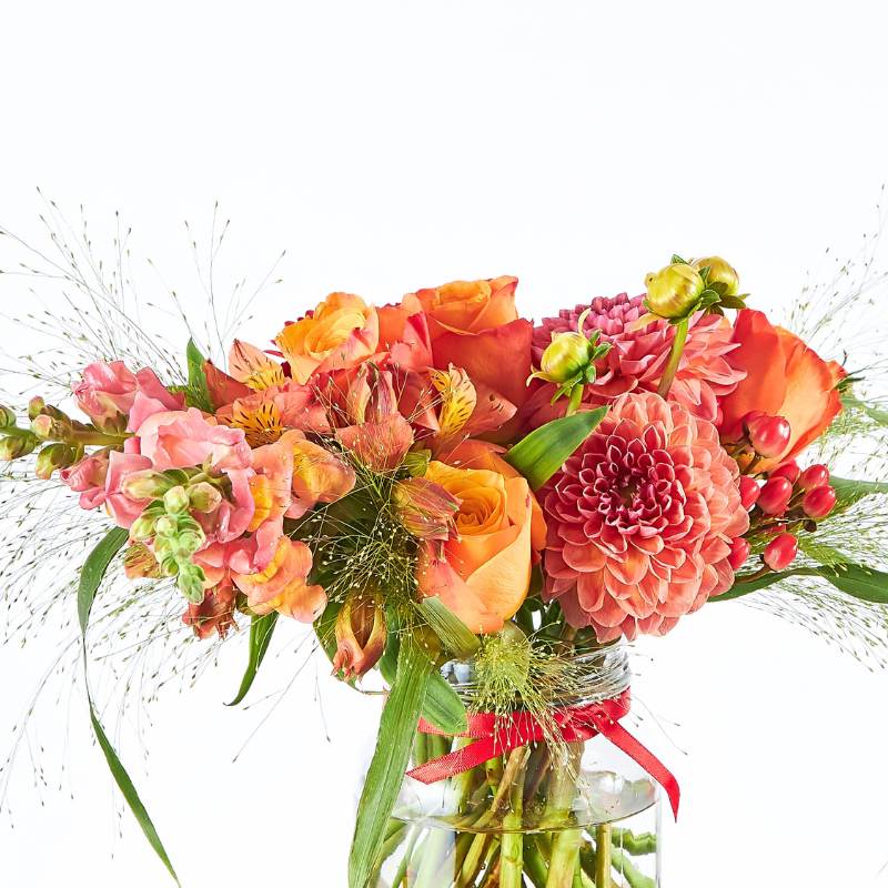 Sunset Glow Flower Arrangement close-up—sunset-toned roses, dahlias, gerberas and snapdragons in a small glass vase | Flower Guy