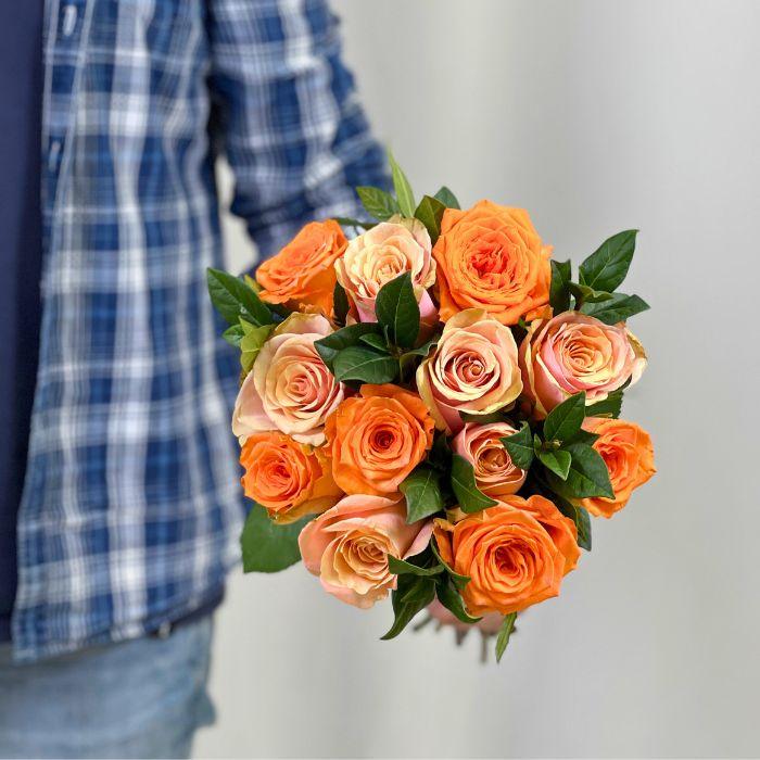 Flower Guy holding Tangerine Tango Rose Bouquet Wrapped With Greenery
