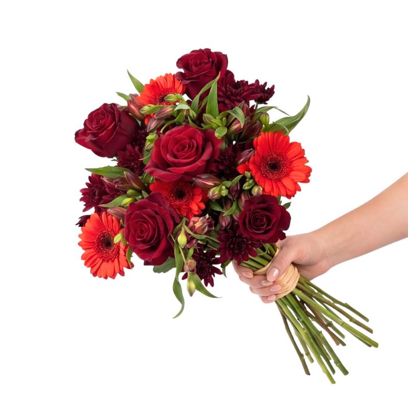 The Sassy Red flower bouquet from Flower Guy with deep red roses, scarlet gerberas, dark red alstroemeria and burgundy chrysanthemums, hand-tied with natural raffia.