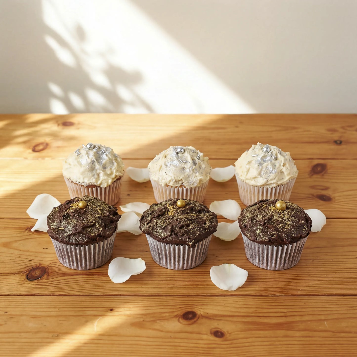 Six luxury cupcakes from Where Frosting Meets Fate lined up with silver vanilla and gold chocolate flavours